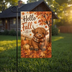 May include: A rectangular garden flag featuring a fluffy brown Highland cow wearing a plaid scarf, sitting among orange autumn leaves and pumpkins. The text Hello Fall is printed in dark brown script at the top, with a small heart icon below.