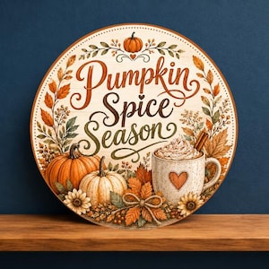 May include: A round wooden sign featuring the text Pumpkin Spice Season in brown cursive script. The design includes illustrations of orange and white pumpkins, a mug with whipped cream and a cinnamon stick, autumn leaves, and sunflowers.