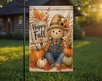 May include: A rectangular garden flag featuring a scarecrow wearing a burlap hat and blue denim overalls, sitting among orange and green pumpkins. A wooden sign with the text Happy Fall and a small orange heart is displayed next to the scarecrow.