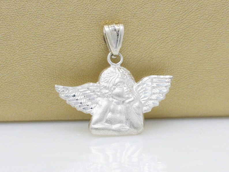 May include: Silver angel pendant charm with detailed wings and a textured finish. The angel is sitting with its head resting on its hand.
