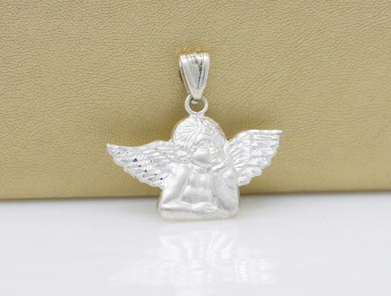 May include: Silver angel pendant charm with detailed wings and a cherub face.