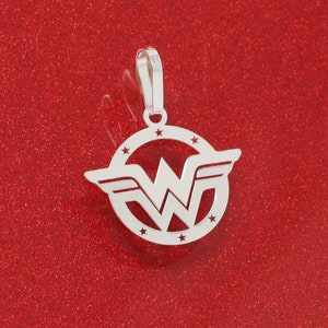 May include: Silver pendant featuring the Wonder Woman logo. The logo is a stylized 'W' with wings, surrounded by a circle of stars.
