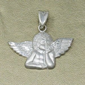 May include: A silver charm pendant featuring a detailed sculpture of an angel with wings. The angel is depicted with its head resting on its hand, looking thoughtful.