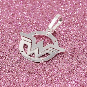 May include: Silver charm pendant featuring the Wonder Woman logo. The logo is a stylized 'W' with wings, surrounded by a circle of stars.