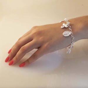 May include: A silver charm bracelet with religious charms, including a cross and a depiction of the Virgin Mary.