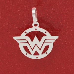 May include: Silver pendant charm featuring the Wonder Woman logo. The logo is a circle with a star at each point, and a stylized 'W' with wings inside the circle.