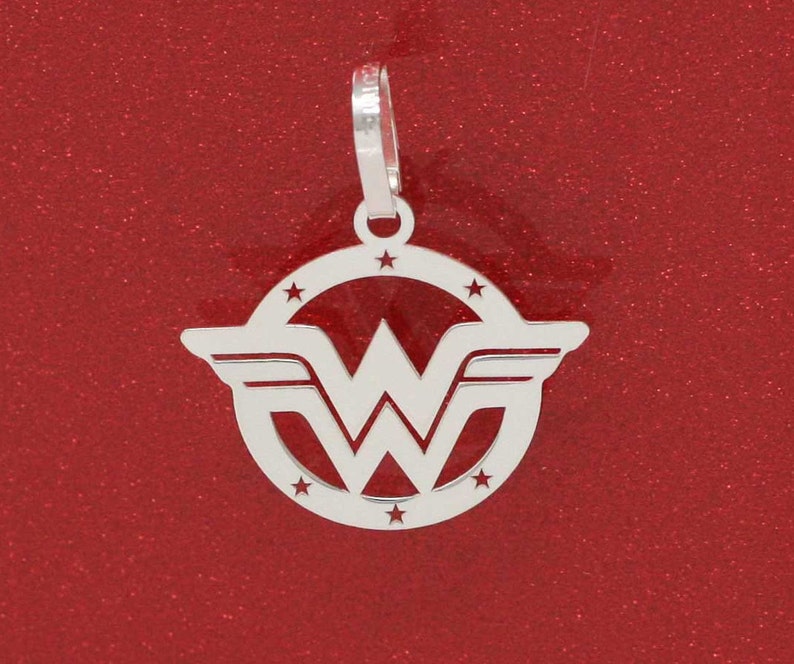 May include: Silver pendant charm featuring the Wonder Woman logo. The logo is a circle with a star at each point, and a stylized 'W' with wings inside the circle.