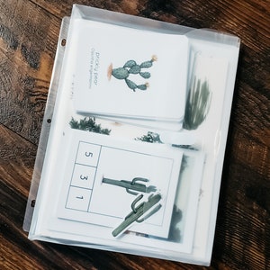 May include: A clear plastic binder with white cards inside. The cards feature illustrations of cacti and the text "prickly pear Opuntia engelmannii". The cards also have numbers 1, 3, and 5 printed on them.