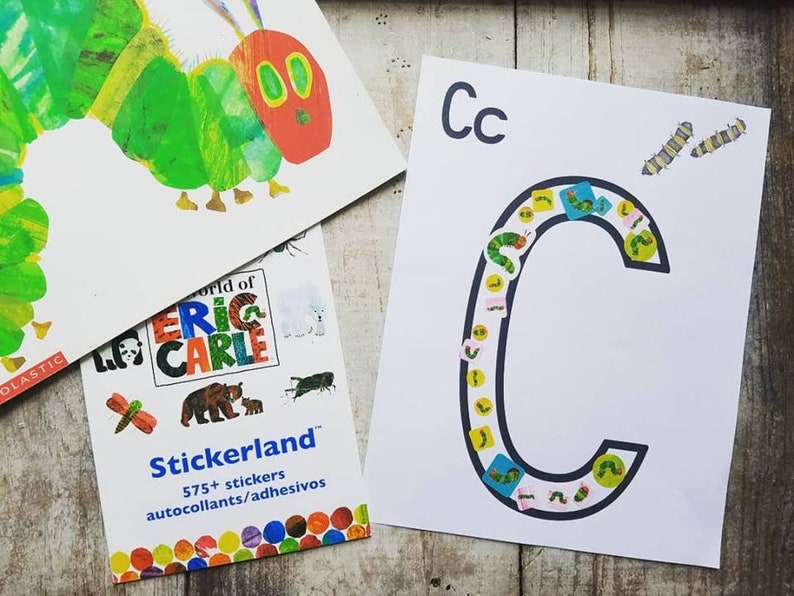 May include: A white sheet of paper with the letter C printed in black. The letter is filled with colorful stickers of caterpillars. The text "Cc" is printed at the top of the page.