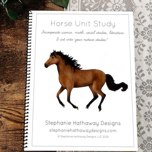 May include: A spiral-bound notebook titled "Horse Unit Study" with a brown horse illustration. The cover includes text about incorporating science, math, and art into nature studies. The notebook is on a wooden surface.