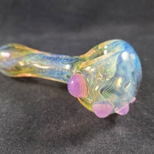 May include: A glass pipe with a swirling blue and yellow pattern and three purple accents.