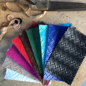 May include: A collection of ten fabric swatches in various colours, including black, blue, red, purple, brown, and green. The fabric has a woven texture and a diamond pattern.