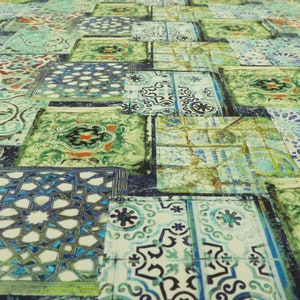 Può includere: Un mosaico di piastrelle colorate con motivi intricati in tonalità di verde, blu e bianco. Le piastrelle sono disposte in modo casuale, creando una superficie visivamente interessante e testurizzata.