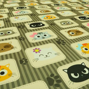 May include: A brown and beige fabric with a repeating pattern of cute cartoon cats in various colours and poses. The cats are wearing bows, flowers, and have different facial expressions. The background is a striped pattern.