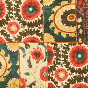 May include: A patchwork fabric with a repeating pattern of stylised flowers in shades of red, yellow, brown, and green.