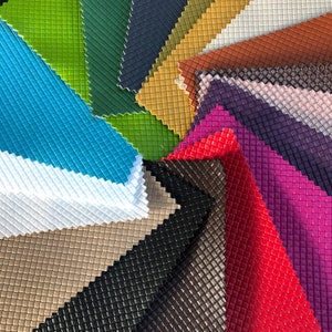 May include: A variety of colours of textured fabric swatches arranged in a circular pattern. The fabric has a diamond-shaped pattern.