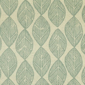 May include: A close-up of a fabric with a repeating pattern of stylized leaves. The leaves are a muted teal color and are outlined with a darker teal. The background is a light beige color.