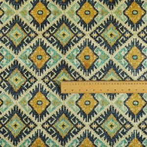 Op de afbeelding: Een stofstaal met een herhalend geometrisch patroon in tinten blauw, geel en wit. De stof heeft een textuur en een geweven uitstraling.