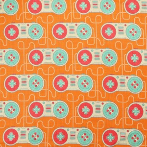 Könnte beinhalten: Ein Stoffmuster mit einem sich wiederholenden Design von Retro-Videospiel-Controllern in hellem Creme, Türkis und Korallenrot auf einem leuchtend orangefarbenen Hintergrund mit dünnen, geschwungenen weißen Linien zwischen den Motiven.