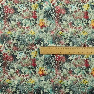 May include: A fabric with a vintage damask pattern in shades of teal, red, yellow, and white. The fabric has a distressed, textured look.