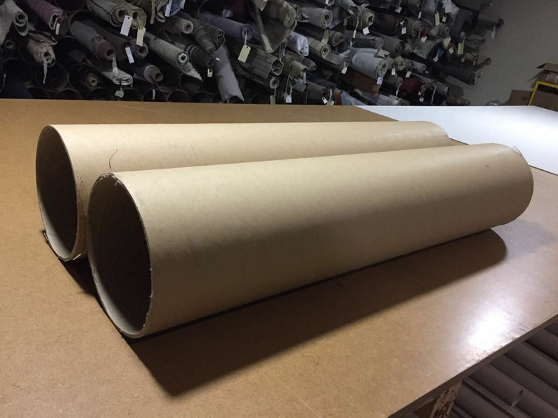 May include: Two large brown cardboard tubes lying on a wooden surface.