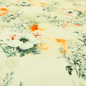 May include: A light beige fabric with a floral print. The flowers are white with a green centre and are surrounded by green leaves. There are also orange and yellow watercolour-like splashes throughout the fabric.