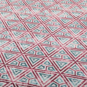 May include: A close-up of a patterned rug with a geometric design. The rug features a repeating pattern of triangles in shades of pink, blue, and white.