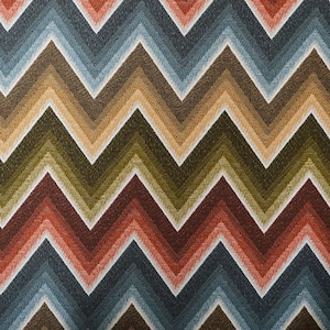 Könnte beinhalten: Nahaufnahme eines Stoffes mit einem Chevron-Muster in Braun-, Grün-, Rot-, Blau- und Weißtönen.