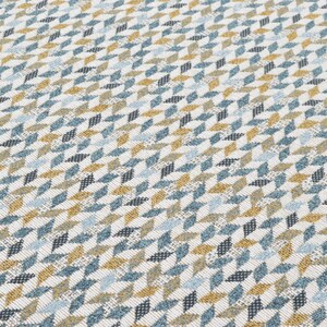 May include: A white fabric with a geometric pattern of blue, gold, and black triangles.