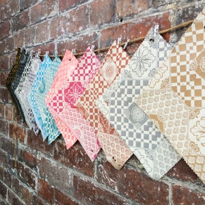 Pode incluir: Uma coleção de amostras de tecido com vários padrões geométricos e florais em tons de marrom, cinza, rosa, azul e branco.