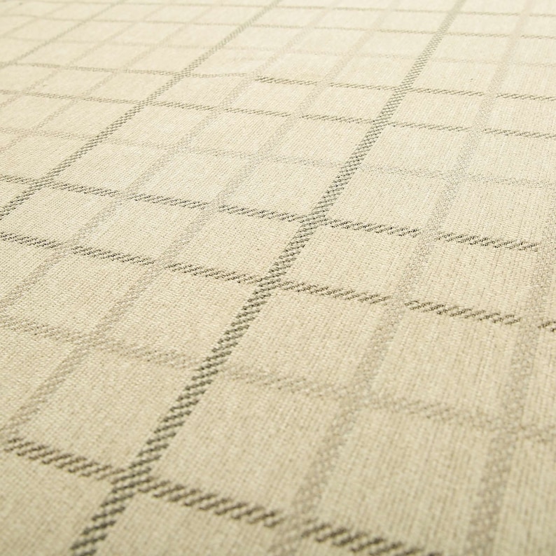 May include: A close-up of a beige fabric with a subtle, woven, geometric pattern. The fabric has a slightly textured surface.
