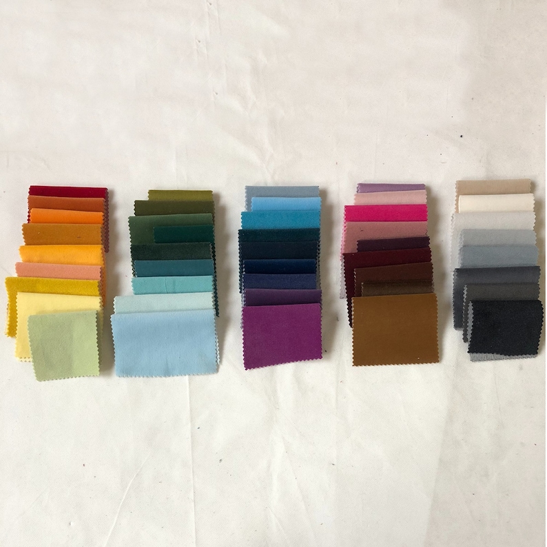 May include: A collection of fabric swatches in various colours, including red, orange, yellow, green, blue, purple, brown, grey, and white. The swatches are arranged in rows, with each row containing a different colour.