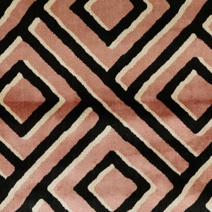 May include: A geometric pattern rug with a black, white, and pink design. The rug features a repeating pattern of squares and diamonds.