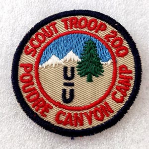 May include: Circular embroidered patch with a blue, white, and green landscape design. The patch features the text "SCOUT TROOP 200 CAMP POUDRE CANYON" in red, with "CIC" in black.