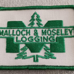 May include: Embroidered patch with a white background and a green border. The patch features the text "MALLOCH & MOSELEY LOGGING" in green, along with a stylized green tree and a large green "M" shape.