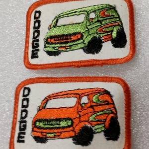 May include: Two embroidered patches featuring a stylized van design. One patch has a green van with orange accents, the other has an orange van with green accents. The word "DODGE" is vertically embroidered on the left side of each patch.