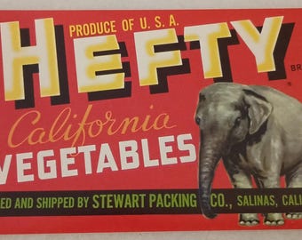 May include: A vintage-style sign with a red background features the word "HEFTY" in large yellow and black letters. Below, it reads "California VEGETABLES" and depicts a gray elephant. The sign is labeled "Produce of U.S.A."
