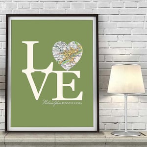 Pode incluir: Um fundo verde com a palavra "LOVE" em letras brancas. O "O" &eacute; substitu&iacute;do por um mapa em forma de cora&ccedil;&atilde;o da Filad&eacute;lfia, Pensilvania.