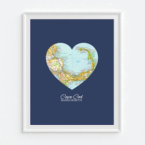 May include: A heart-shaped map of Cape Cod, Massachusetts, on a dark blue background. The map shows the roads, towns, and coastline of the Cape. The text "Cape Cod MASSACHUSETTS" is printed below the map.