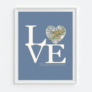 Pode incluir: Um fundo azul com a palavra "LOVE" em letras brancas. O "O" &eacute; substitu&iacute;do por um mapa em forma de cora&ccedil;&atilde;o da Filad&eacute;lfia, Pensilvania.