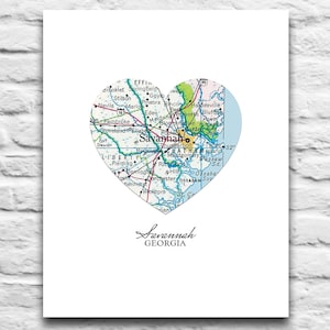 May include: A heart-shaped map of Savannah, Georgia, printed on white paper. The map is in shades of green, blue, and yellow, with roads and place names visible. The word "Savannah" is written in cursive below the map, with "GEORGIA" below it.