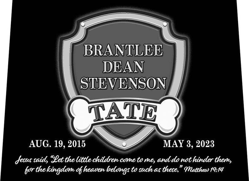 May include: A black and white memorial plaque with a shield shape and a bone on each side. The shield has the text 'BRANTLEE DEAN STEVENSON TATE' and the dates 'AUG. 19, 2015' and 'MAY 3, 2023'. The plaque also has a quote from the Bible: 'Jesus said, 'Let the little children come to me, and do not hinder them, for the kingdom of heaven belongs to such as these.' Matthew 19:14'