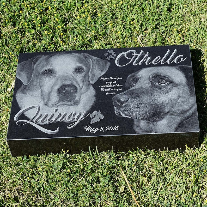 Puede incluir: Un monumento conmemorativo para mascotas de granito negro con retratos grabados de dos perros, Quincy y Othello. El monumento incluye la fecha 8 de mayo de 2016 y la inscripci&oacute;n "Papus thank you for your unconditional love. We will miss you forever."