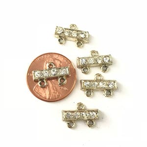 May include: Five gold-tone metal connector pieces with clear rhinestone accents. Each connector has two loops on either end.