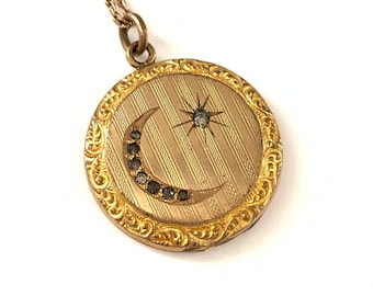May include: A gold locket necklace with a crescent moon and star design. The locket has a detailed engraved border.