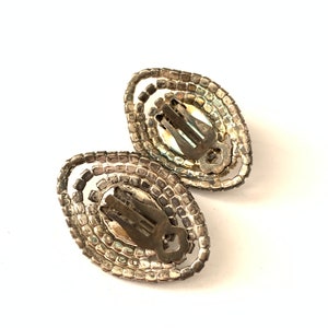 Op de afbeelding: Een paar zilverkleurige clip-on oorbellen met ovale strass.