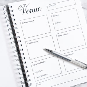 May include: A white spiral bound notebook with a black title "Venue" and sections for planning a wedding or event. The notebook has sections for venue name, address, website, planner contact, cocktail hour, menu choices, signature drinks, price per plate, guest minimum and maximum, and miscellaneous notes.