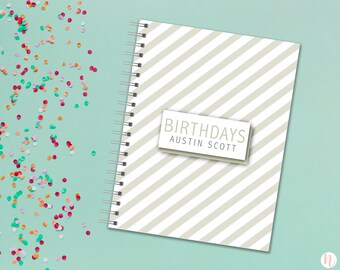 May include: A white and gray striped spiral bound notebook with the text "BIRTHDAYS AUSTIN SCOTT" on a white label.