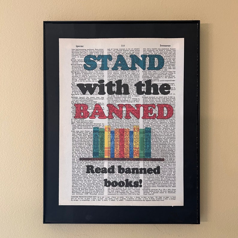 Stand with the banned. Read banned books - printed on a dictionary page with an image of colorful books on a shelf