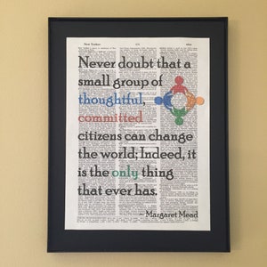 May include: A framed print with a quote by Margaret Mead on a vintage dictionary page background. The quote reads: "Never doubt that a small group of thoughtful, committed citizens can change the world; Indeed, it is the only thing that ever has."
